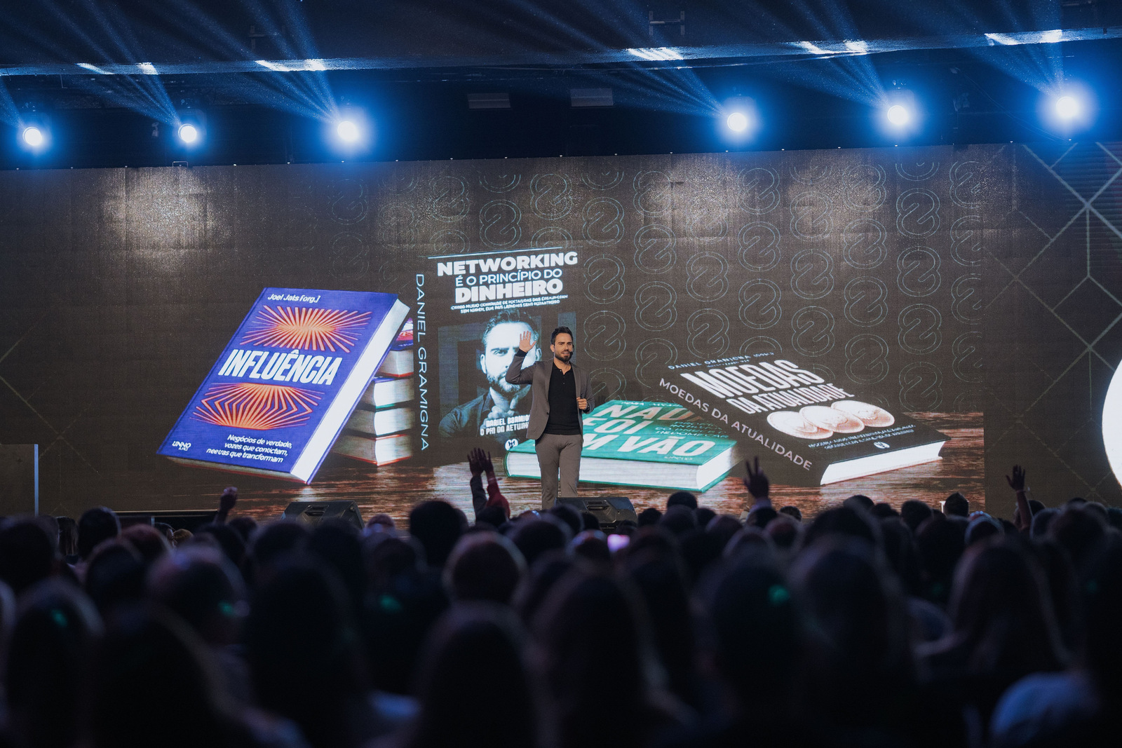 Daniel Gramigna em palestra, com público à frente do palco