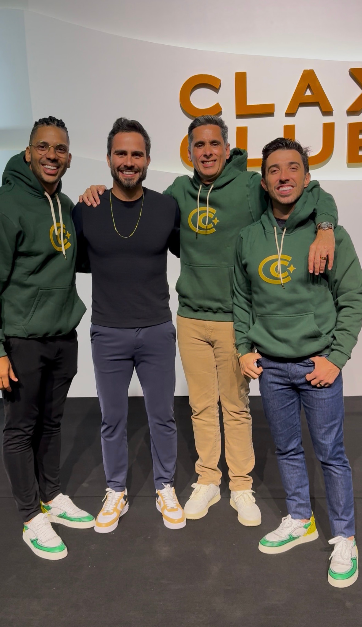 Encontro de Daniel Gramigna em grupo diante do painel Clax Club